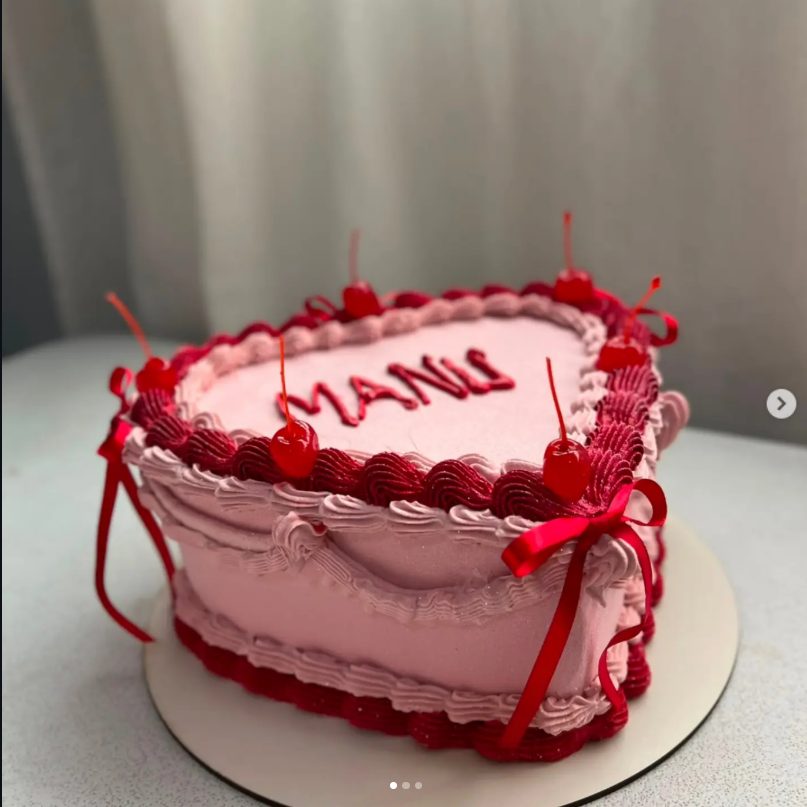 Bolo artesanal branco com respingos dourados e detalhes em rosa